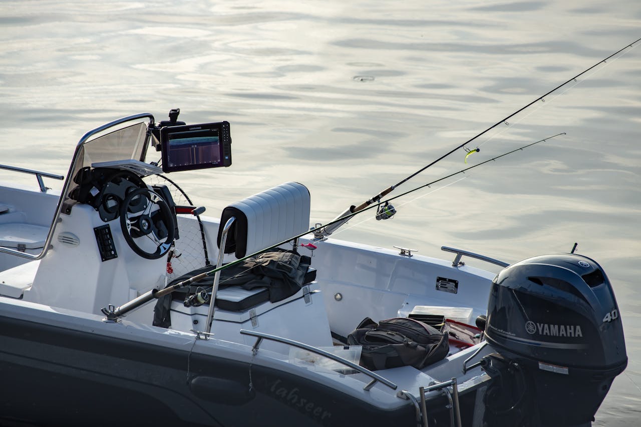 Close-up of a fishing motorboat with rods and equipment on calm water, ideal for leisure and outdoor adventure.